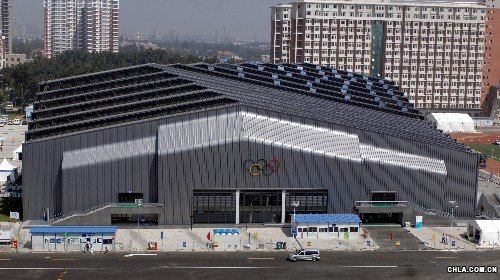 中國農業大學體育館外景。中國農業大學體育館是北京奧運會新建場館,是北京奧運會摔跤比賽館。體育館造型新穎而不張揚,采用“門式鋼架”結構,形成了高低錯落的造型,并充分利用了屋面的造型特征,在場館頂部安裝了400多個高低錯落分層排列的玻璃窗,形成效果極佳的自然采光通風效果,從而減少空調的使用率,達到節能的目的。 新華社發