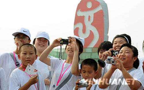 7月26早晨，一群少年游客在“中國印”前拍照。 目前，正在搭建中的“中國印”成為天安門廣場上最受人矚目的奧運景觀。 新華社記者 楊磊 攝